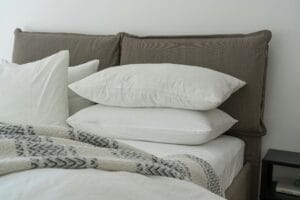 Foto de uma cama focando nos 6 travesseiros em cima