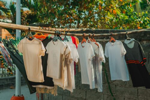 Foto de uma área aberta com roupas em cabides secando no varal